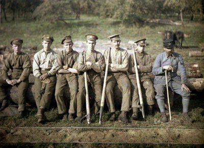 Canadese soldaten met een kanthaak zitten op de stam van een boom voor een zagerij, Quesmy, Oise, Frankrijk, 1917 door Fernand Cuville